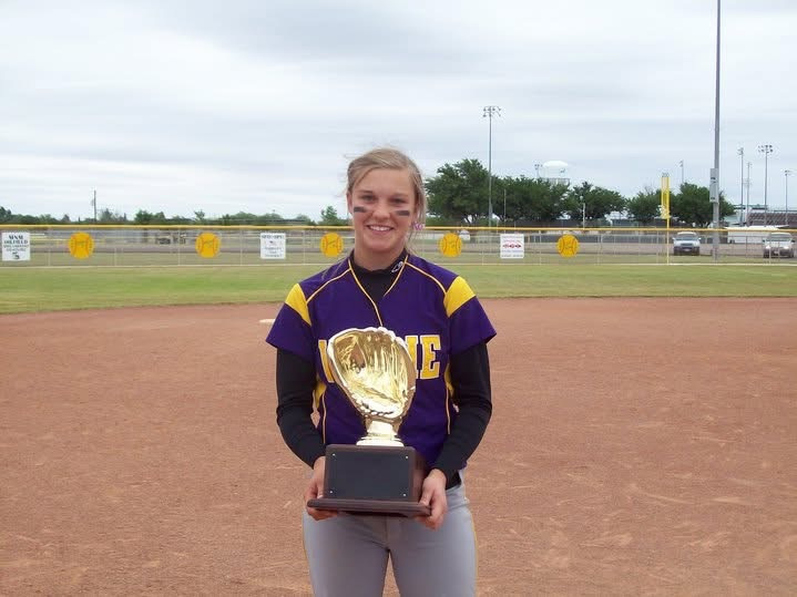 Brianna Halford standing on a softball field with a trophy